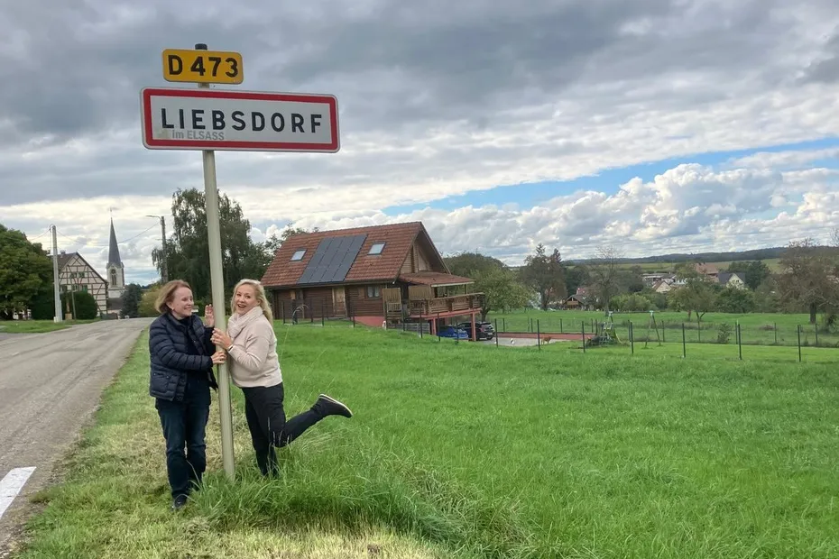 Deux américaines devant le panneau du village de Liebsdorf en Alsace.
